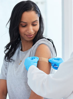 A woman getting a band-aid following a vaccine