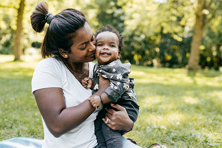 A mother presses her cheek against her baby