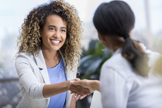 doctor shakes hand with smiling professional